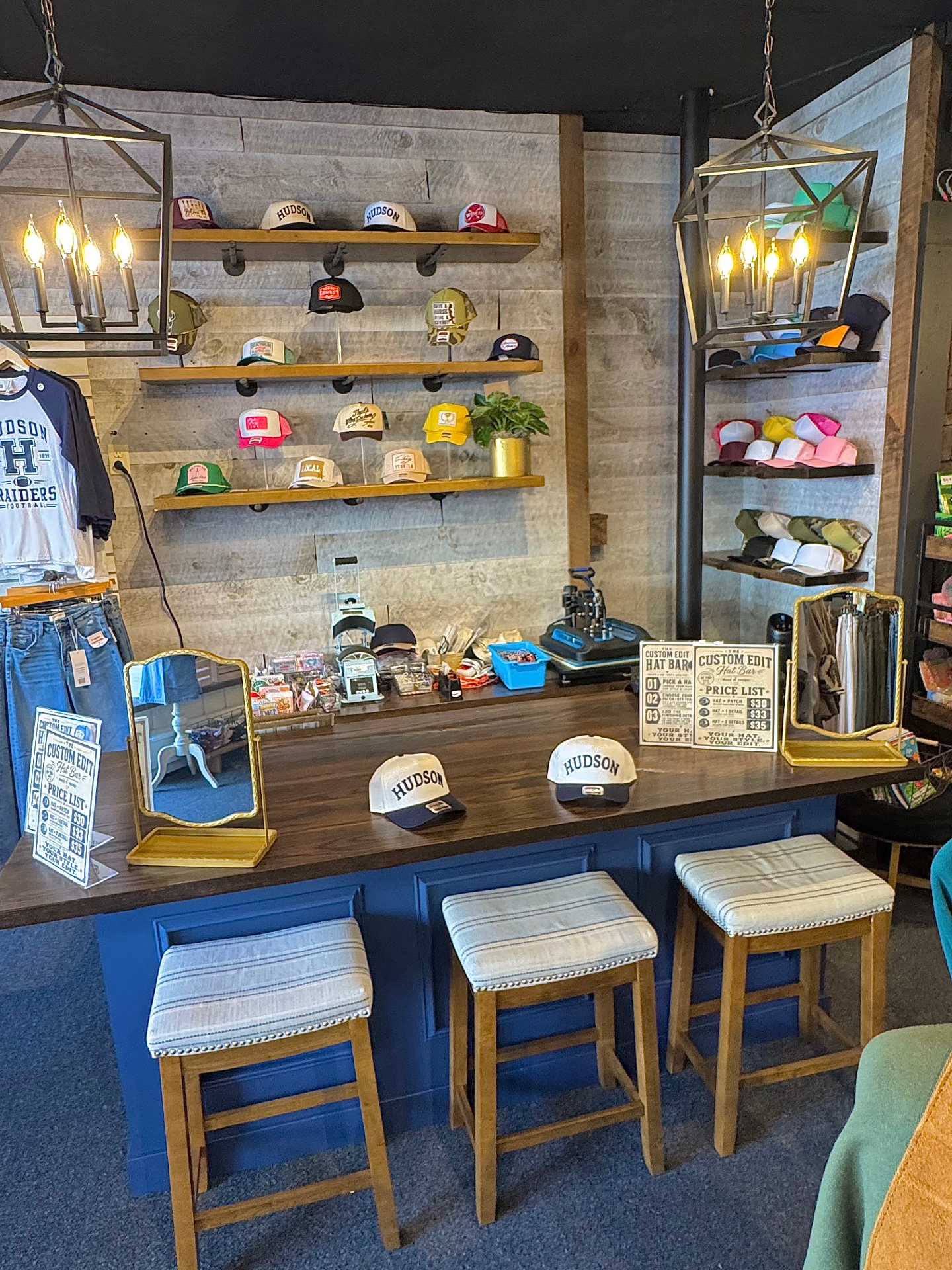 The navy custom hat bar at The Custom Edit, lined with hats and trim